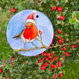 robin in a christmas hat printed onto a white ceramic ornament
