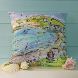 person sitting on a cliff top sketching Freshwater bay on the Isle of Wight printed onto a cushion.